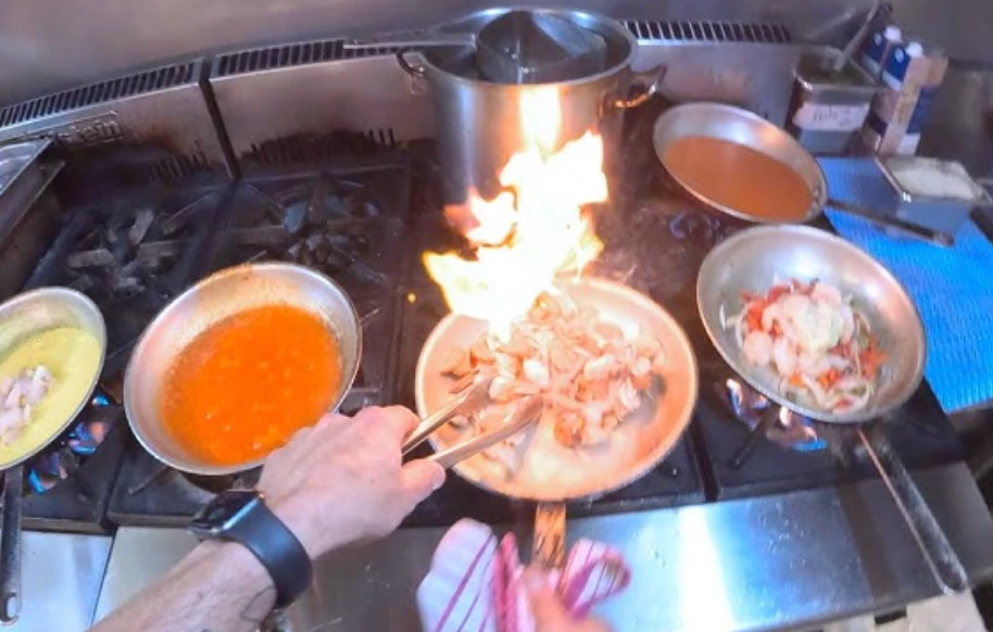 First-person view of a line cook working the stove